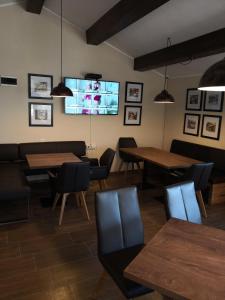 a dining room with tables and a flat screen tv at Hotel Hijata in Stara Zagora