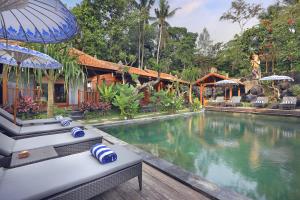 a resort with a swimming pool and a house at Batu Agung Villa Ubud in Ubud