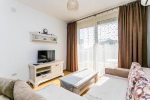 een woonkamer met een bank en een tv bij Apartments LORA Cetinjska in Budva