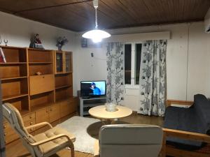 薩拉的住宿－SÄHKÖPIRTTI SALMIVAARA，客厅配有桌子和电视