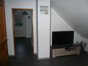 een woonkamer met een flatscreen-tv op een tafel bij La Garenne in Camiers