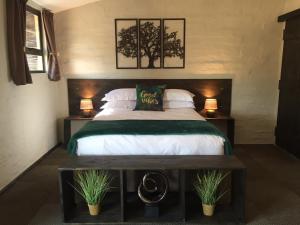 - une chambre avec un grand lit, 2 lampes et 2 plantes dans l'établissement TreeTopia Guesthouse, à Benoni