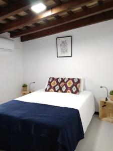 a bedroom with a bed with a blue blanket at CH Apartments in Conil de la Frontera