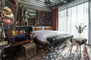 Mestyle Garage Hotel في بانكوك: غرفة نوم بسرير واريكة وطاولة