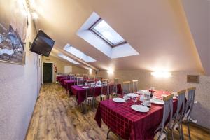 uma sala de jantar com mesas e cadeiras vermelhas e uma clarabóia em Hotel House of the Hunter em Toksovo