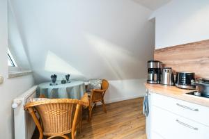 - une cuisine avec une table et des chaises dans la chambre dans l'établissement Ferienwohnung im Reetdachhaus, à Heringsdorf