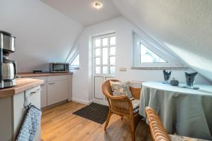 - une cuisine avec une table et des chaises dans la chambre dans l'établissement Ferienwohnung im Reetdachhaus, à Heringsdorf