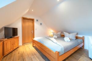1 dormitorio con 1 cama y TV de pantalla plana en Ferienwohnung im Reetdachhaus en Heringsdorf