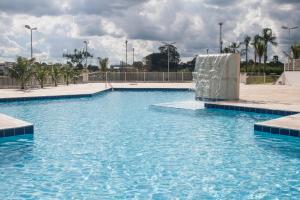 a swimming pool with a fountain in the middle at The Hill Hotéis Executive in São Carlos