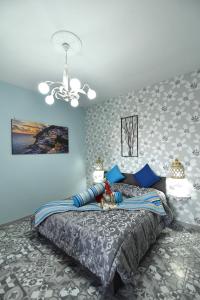 una camera da letto con un grande letto con pareti blu di B&b Le Cycas a Castellammare di Stabia