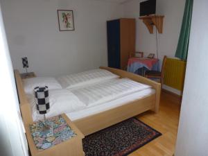 a bedroom with a bed and a table with a rug at Pension Elke Rothenburg in Rothenburg ob der Tauber