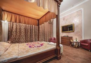 a bedroom with a canopy bed and a chair at Alex Hotel on Vasilyevsky Island in Saint Petersburg