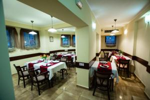 a restaurant with tables and chairs in a room at Hotel Ferdinand in Constanţa