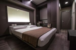 una camera da letto con un grande letto con una grande finestra di Hotel Bigio a San Pellegrino Terme