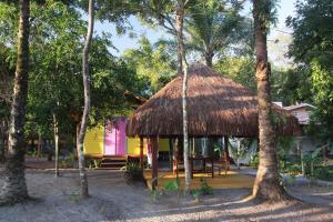 a hut with a thatched roof in a forest at Casinha Amarela EcoLodge Boipeba in Ilha de Boipeba