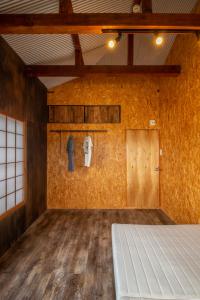 Habitación vacía con cama y pared en CRAFT en Matsubara