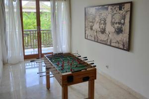 una mesa de futbolín en una habitación con una foto en la pared en Dream villa Seminyak, en Seminyak