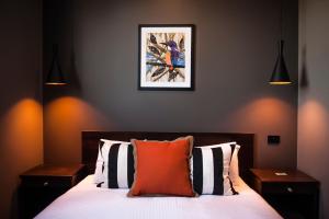 um quarto com uma cama com uma almofada laranja em Criterion Hotel Sale em Sale