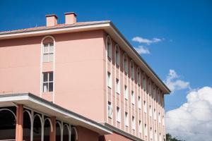 a pink building with a sky in the background at The Hill Hotéis Executive in São Carlos