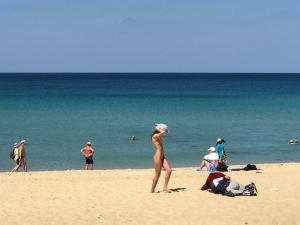 una mujer parada en la arena en una playa en KARON SINO House, en Karon Beach