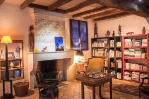 a living room with a fireplace and book shelves at Chateau De Champdolent in Champdolent