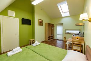 a green room with a bed and a desk and a table at Bestes apartamenti in Kocēni