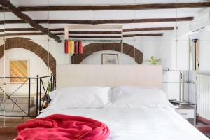 a bedroom with a white bed with a red blanket on it at Cedro Terrace&Jacuzzi - Loft in Trastevere in Rome