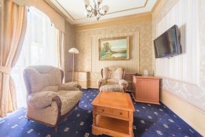 a living room with two chairs and a tv at Ukraina Hotel in Simferopol