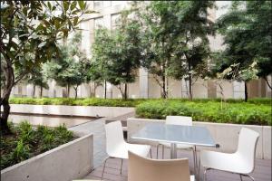 a table and chairs in a courtyard with a building at Puerta Alameda Suites México in Mexico City