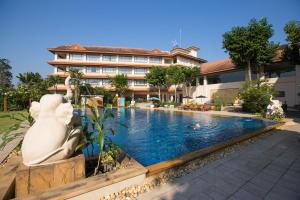 un hotel con piscina frente a un edificio en The Imperial River House Resort, Chiang Rai, en Chiang Rai