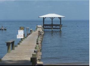 a wooden pier with a gazebo in the water at Magnolia Beach Inn - Fairhope in Fairhope +6 photos