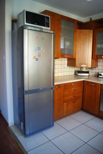 a kitchen with a stainless steel refrigerator with a microwave at Przybobrze Apt. in Jelenia Góra