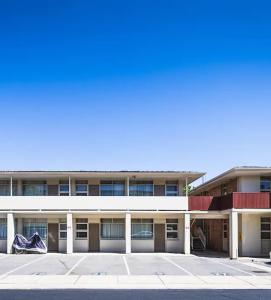 格莱内尔格Glenelg beach gateway Studio Apartment的建筑物前的空停车场