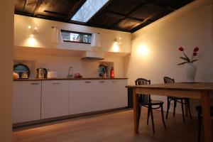 a kitchen with white cabinets and a wooden table at Nachtwacht Apartment in Amsterdam