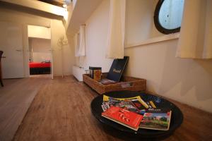 una habitación con una mesa con libros y un reloj en Nachtwacht Apartment, en Ámsterdam