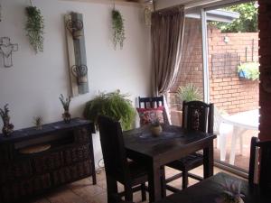 a dining room with a wooden table and chairs at Kudu Cottages in Kathu