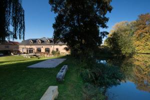 una casa seduta accanto a un corpo d'acqua di Ô jardin de boutancourt a Boutancourt