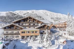 eine Skihütte in den Bergen mit Schnee auf dem Boden in der Unterkunft Hotel Lärchenhof in Katschberghöhe