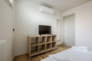 a bedroom with a tv on a stand with a bed at Aparthotel Sant'Orsola in Bologna
