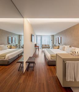ein großes Hotelzimmer mit zwei Betten und einer Couch in der Unterkunft Lux Lisboa Park in Lissabon