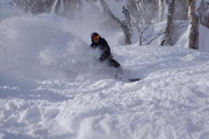 a person is skiing down a snow covered slope at Monkey Rider in Hakuba