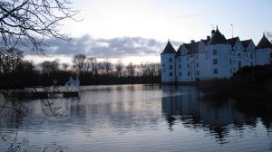 un château sur l'eau avec un bateau à l'intérieur dans l'établissement FEWO Muschel, à Glücksburg
