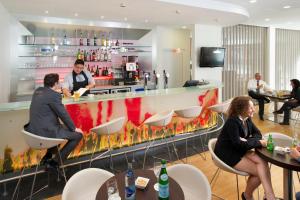 a group of people sitting at tables in a bar at ibis Esch Belval in Esch-sur-Alzette