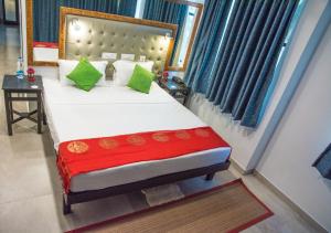 a bedroom with a large bed with green pillows at 36 Palms Residency - Sea View Villa in Cochin +37 photos