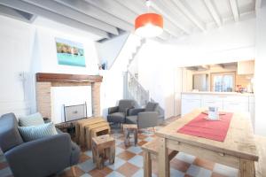 een woonkamer met een tafel en stoelen en een open haard bij Entre Mer et Golf in Étretat