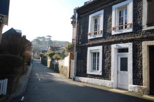 ein Backsteinhaus mit weißer Tür auf einer Straße in der Unterkunft Entre Mer et Golf in Étretat