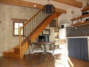 Un comedor con una escalera y una mesa. en Domaine Saint Martin, en Valliguières