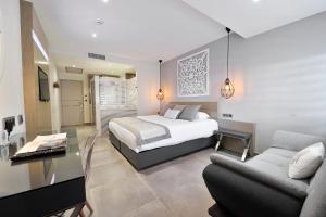 a bedroom with a bed and a desk and a couch at Le Spinaker in Le Grau-du-Roi