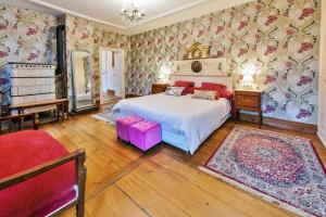 - une chambre avec un lit blanc et du papier peint floral dans l'établissement Chambres d'hôtes Château De Grunstein, à Stotzheim