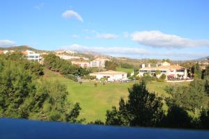 - Vistas a un campo de golf con casas y árboles en Miraflores Golf Gardens II Luxe Appartement at Riviera del Sol, en Mijas Costa